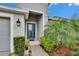 Inviting front entry with teal door and landscaping at 7102 Wesley Palm Way, Wesley Chapel, FL 33545