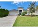 One story home with gray siding and a two car garage at 7102 Wesley Palm Way, Wesley Chapel, FL 33545