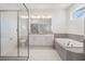 Spa-like bathroom with double vanity, soaking tub, and walk-in shower at 7678 Notched Pine Bnd, Wesley Chapel, FL 33545