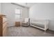 Bright Bedroom with a crib, armchair, and dresser at 7678 Notched Pine Bnd, Wesley Chapel, FL 33545