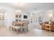 Open concept living and dining area with wood-look floors and access to patio at 7678 Notched Pine Bnd, Wesley Chapel, FL 33545