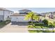 Two-story house with a three-car garage and palm tree landscaping at 7678 Notched Pine Bnd, Wesley Chapel, FL 33545