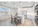 Bright kitchen with white cabinets and an island with seating at 7678 Notched Pine Bnd, Wesley Chapel, FL 33545