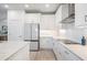 White kitchen with stainless steel appliances and quartz countertops at 7678 Notched Pine Bnd, Wesley Chapel, FL 33545