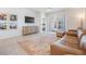 Comfortable living room with leather sofa and access to backyard patio at 7678 Notched Pine Bnd, Wesley Chapel, FL 33545