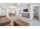 Open living room features a spacious layout, leather sofas, and a large TV at 7678 Notched Pine Bnd, Wesley Chapel, FL 33545
