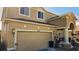 Two-story house with tan exterior, arched entryway, and two-car garage at 8999 Founders Cir, Palmetto, FL 34221
