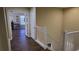 Upstairs hallway with light walls and dark wood floors at 8999 Founders Cir, Palmetto, FL 34221
