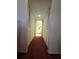 Long hallway with closets and carpet leading to the bathroom at 1010 Bowsprit Ln # 0, Holiday, FL 34691