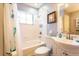 Bright, clean bathroom features a vanity, toilet, shower/tub with teal accents at 10405 N Woodmere Rd, Tampa, FL 33617