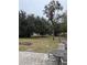 Outdoor patio area with table and chairs overlooks the serene and expansive backyard at 10405 N Woodmere Rd, Tampa, FL 33617