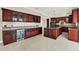 Large kitchen with dark wood cabinets, granite countertops, and island at 11120 Kempton Vista Dr, Riverview, FL 33579