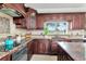 Modern kitchen with dark wood cabinets and granite countertops at 11120 Kempton Vista Dr, Riverview, FL 33579