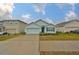 Light blue single story house with a two-car garage, viewed from the street at 11520 Koti Creek Ln, Thonotosassa, FL 33592