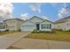 Front view of a single-story house with a light blue exterior and a two-car garage at 11520 Koti Creek Ln, Thonotosassa, FL 33592