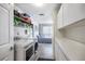 Laundry room with washer, dryer, and extra storage shelves at 1230 Nelson St, Dunedin, FL 34698