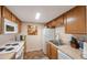 White appliances and light oak wood cabinets in this galley kitchen at 1290 83Rd N Ave # D, St Petersburg, FL 33702