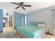 Spacious bedroom with ceiling fan, light teal bedding, and built-in shelving at 13494 Tyringham St, Spring Hill, FL 34609