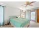 Relaxing bedroom featuring a large bed, ceiling fan, and stained-glass window at 13494 Tyringham St, Spring Hill, FL 34609