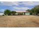 A light green house with a metal roof and a large yard at 13494 Tyringham St, Spring Hill, FL 34609