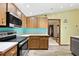 View of kitchen with wood cabinets, and a modern stove at 13494 Tyringham St, Spring Hill, FL 34609