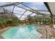 Large screened pool with brick patio and surrounding greenery at 13494 Tyringham St, Spring Hill, FL 34609