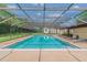 Community swimming pool with screened enclosure and lounge chairs at 13602 S Village Dr # 1112, Tampa, FL 33618