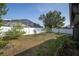 Fenced backyard featuring a well-maintained lawn and mature landscaping, with a screened enclosure in the background at 1400 Solar Dr, Holiday, FL 34691