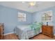 Bright bedroom with a ceiling fan, two windows, and a full size bed at 1400 Solar Dr, Holiday, FL 34691