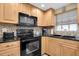 Well-lit kitchen featuring stainless steel appliances, granite countertops, and wood cabinetry at 1400 Solar Dr, Holiday, FL 34691