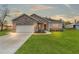 House exterior featuring stone accents, a two-car garage, and a well-manicured lawn at 15171 Pomp Parkway, Weeki Wachee, FL 34614