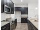 Modern kitchen with dark cabinets, granite countertops, and stainless steel appliances at 15171 Pomp Parkway, Weeki Wachee, FL 34614