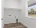 Laundry room with white cabinets and wood-look floors at 15171 Pomp Parkway, Weeki Wachee, FL 34614