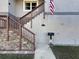 Front entrance with stone steps, wooden railing, and American flag at 1600 Pennsylvania Ne Ave, St Petersburg, FL 33703