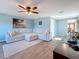 Bright living room featuring a sectional sofa, ceiling fan, and wood-look floors at 1600 Pennsylvania Ne Ave, St Petersburg, FL 33703