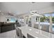 Bright dining area with white table and gray chairs, overlooking pool at 16015 Redington Dr, Redington Beach, FL 33708