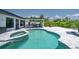 Inviting pool area with spa, outdoor kitchen, and lounge chairs at 16015 Redington Dr, Redington Beach, FL 33708