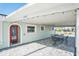 Covered patio with a table and chairs, adjacent to the front door of the house at 17602 Sterling Ter, Redington Shores, FL 33708