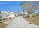 Side view of a light teal home with a paved walkway leading to the house and patio at 17602 Sterling Ter, Redington Shores, FL 33708