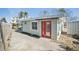 House exterior featuring a red door and concrete driveway at 17602 Sterling Ter, Redington Shores, FL 33708