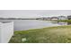 Lake view from backyard with grassy area and white fence at 2667 89Th Street E Cir, Palmetto, FL 34221