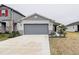 One-story house with gray garage door and landscaping at 2667 89Th Street E Cir, Palmetto, FL 34221