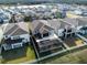 Aerial view of houses with screened-in pools and fenced yards at 3071 Marine Grass Dr, Wimauma, FL 33598