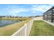 Tranquil lake view with community homes in the background at 3071 Marine Grass Dr, Wimauma, FL 33598