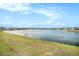 Serene lake view with lush green landscaping at 3071 Marine Grass Dr, Wimauma, FL 33598