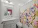 Clean bathroom with white vanity, glass sink, and floral shower curtain at 320 N Madison Ave, Clearwater, FL 33755