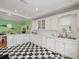 White kitchen boasts stainless steel appliances and a checkerboard floor at 320 N Madison Ave, Clearwater, FL 33755