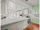 Bright white kitchen with checkered floor and stainless steel appliances at 320 N Madison Ave, Clearwater, FL 33755