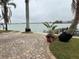 Brick paved patio overlooks waterfront with palm trees and private dock at 341 E Madeira Ave, Madeira Beach, FL 33708