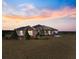 Brick and siding one-story home with landscaped yard at sunset at 36511 Frazee Hill Rd, Dade City, FL 33523